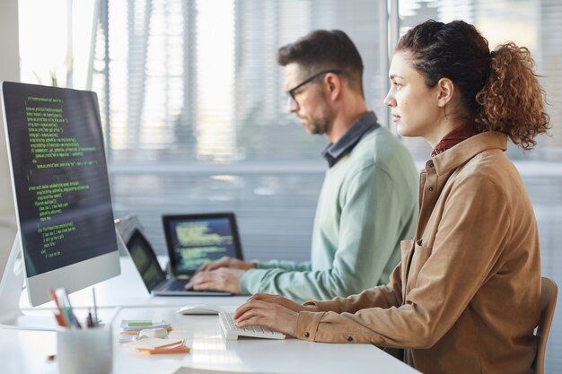 Software developers coding in modern office